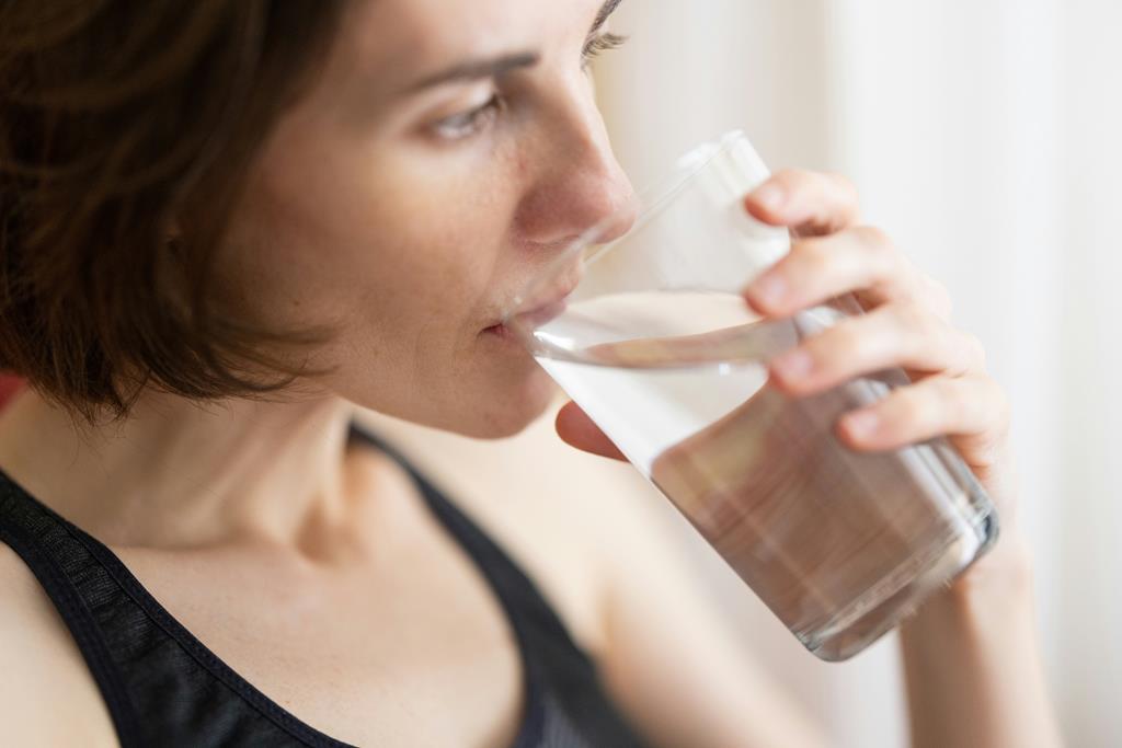 mulher bebendo água para realizar atividades de endurance