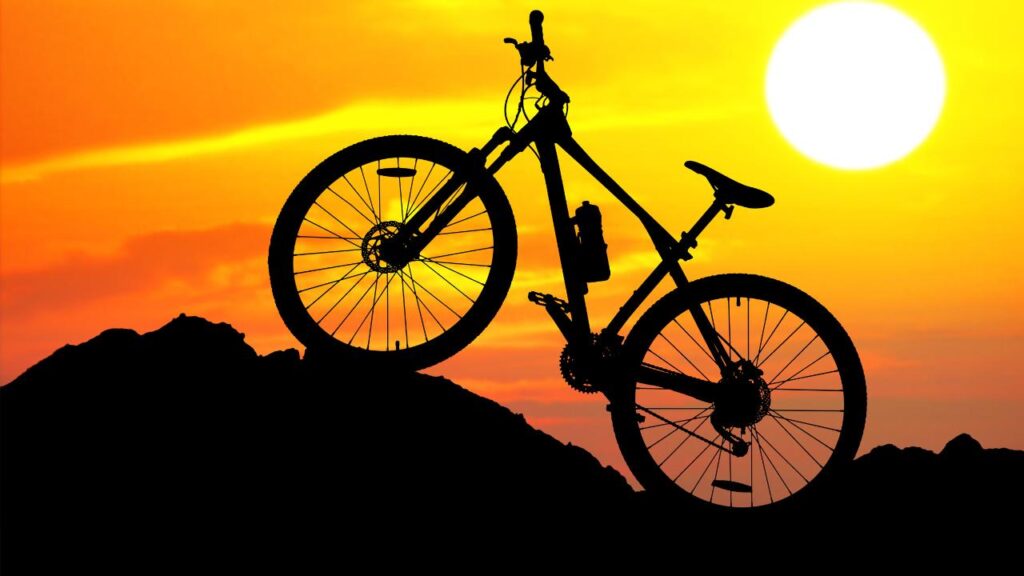 Foto de uma bicicleta e um lindo por do sol ao fundo, uma das belezas que o ciclismo proporciona