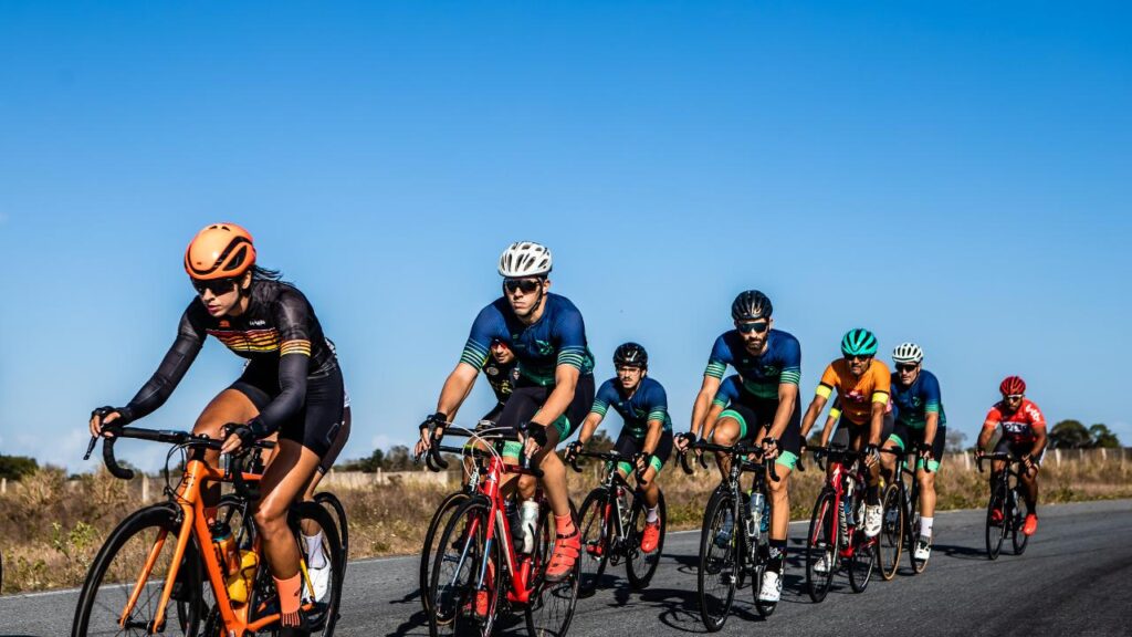 Grupo de ciclistas, andando por uma estrada