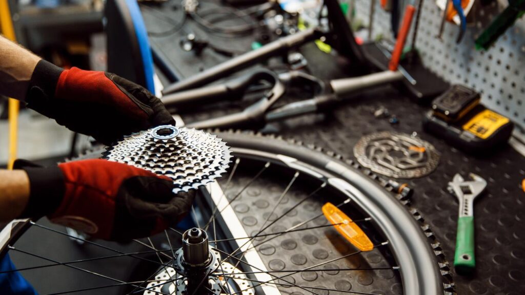 bicicleta toda desmontada e um homem realizando manutenção de bike para novatos.