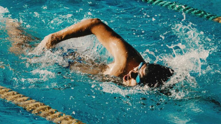 homem praticando natação em piscina