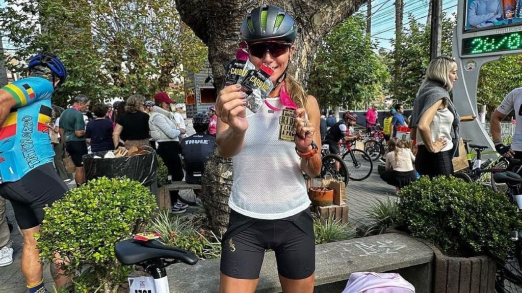 atleta de ciclismo em parceria com a probiótica segurando gel carb up