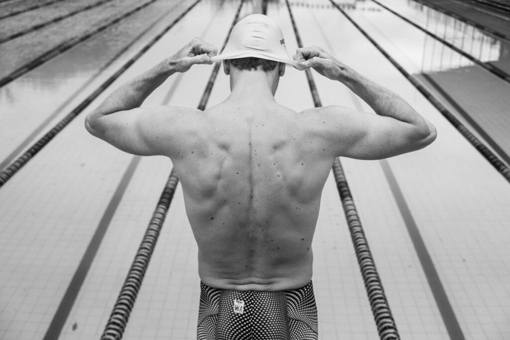 atleta César Cielo, em parceria com a Probióica, praticando natação ao se preparar para mergulhar em piscina