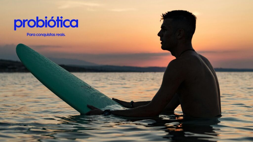 surfista no mar com sua prancha ao por do sol